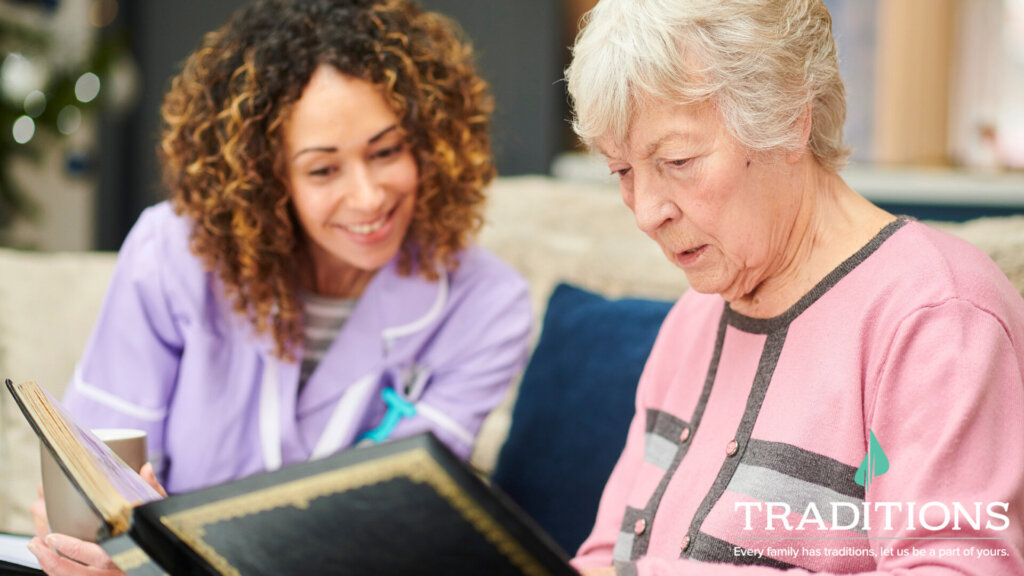 A woman in purple overlooks the elderly woman in pink