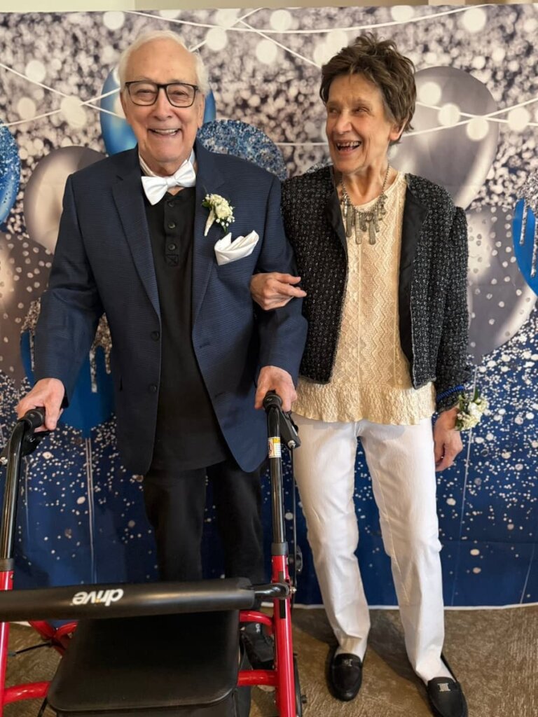 Residents dressed up and smiling together at a senior prom celebration at Meadow Brook Senior Living