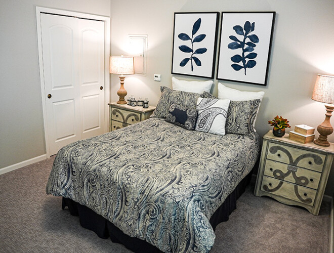 This is a photo of a bed with gray sheets at Meadow Brook